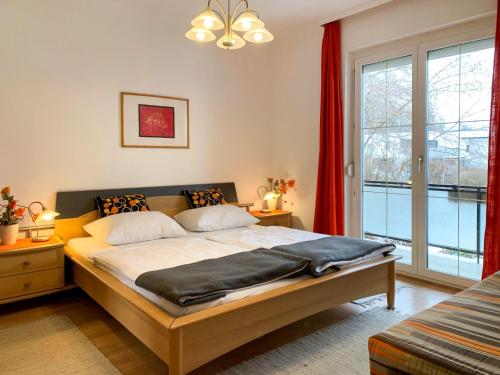 a bedroom with a bed and a large window at Apartment Meran-2 by Interhome in Görtschach