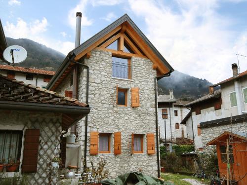 an old house in a village with mountains in the background at Apartment Albergo Diffuso - Cjasa de Barce-1 by Interhome in Barcis