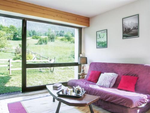 Holiday Home Les Pelarnys by Interhome في شامونيه مون بلان: غرفة معيشة مع أريكة أرجوانية ونافذة كبيرة