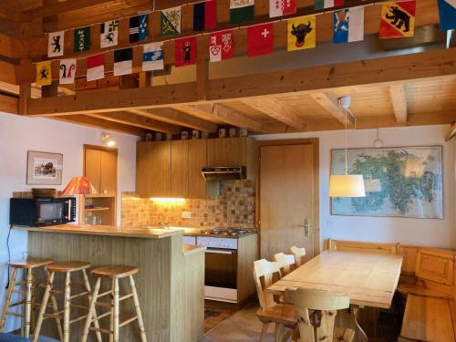 cocina con mesa de madera y taburetes en Apartment Arsets 203-12 by Interhome, en Arveyes