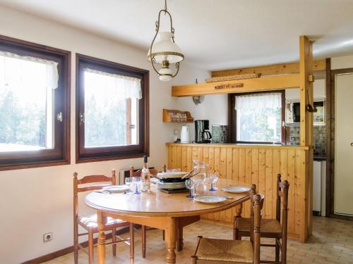 a kitchen with a wooden table with chairs and a dining room at Holiday Home Les Pelarnys by Interhome in Chamonix