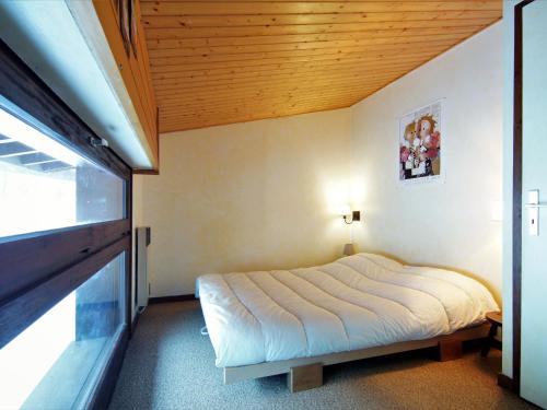 une chambre avec un lit avec un plafond en bois dans l'établissement Holiday Home Les Pelarnys by Interhome, à Chamonix-Mont-Blanc