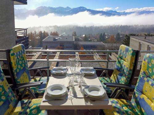 a table and chairs on a balcony with a view at Apartment Jeanne d'Arc-1 by Interhome in Crans-Montana
