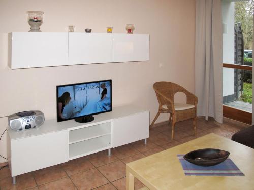 a living room with a tv on a white cabinet at Holiday Home Strandvilla - LUB110 by Interhome in Lubmin