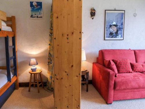 - un salon avec un canapé rouge et un lit dans l'établissement Apartment Les Pècles by Interhome, à Chamonix-Mont-Blanc