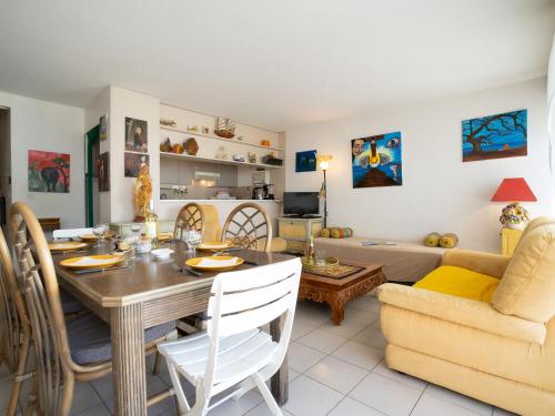 jadalnia i salon ze stołem i krzesłami w obiekcie Apartment Les Patios de Salonique by Interhome w mieście Le Grau-du-Roi