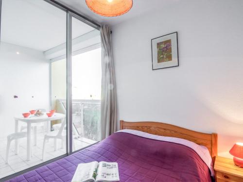1 Schlafzimmer mit einem lila Bett und einem Balkon in der Unterkunft Apartment Voiles d'Or-Gênois-1 by Interhome in Le Grau-du-Roi