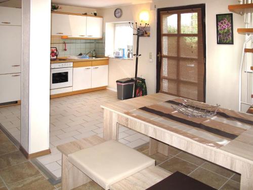 eine Küche mit weißen Schränken und einem Holztisch in der Unterkunft Holiday Home Am See II by Interhome in Verchen