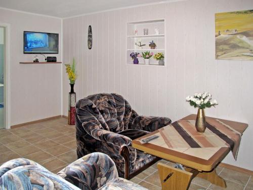 ein Wohnzimmer mit einem Stuhl und einem Tisch in der Unterkunft Holiday Home Am See II by Interhome in Verchen