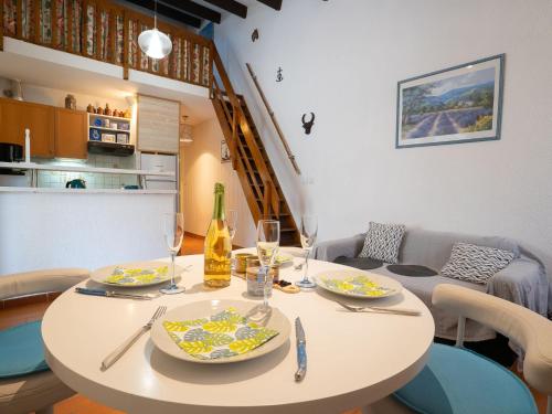 a white table with plates and wine glasses on it at Holiday Home Les Maisons de la Plage-4 by Interhome in Le Grau-du-Roi
