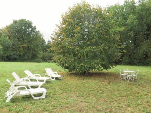 un grupo de sillas y mesas blancas bajo un árbol en Holiday Home Le Petit Gîte by Interhome, en Jayac