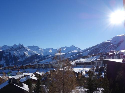 a view of a town with snow covered mountains at Apartment Cote Louve by Interhome in La Toussuire