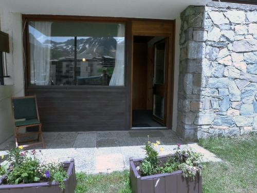 a house with two flower boxes in front of a door at Studio Le 2100 A et B - Lavachet-8 by Interhome in Tignes