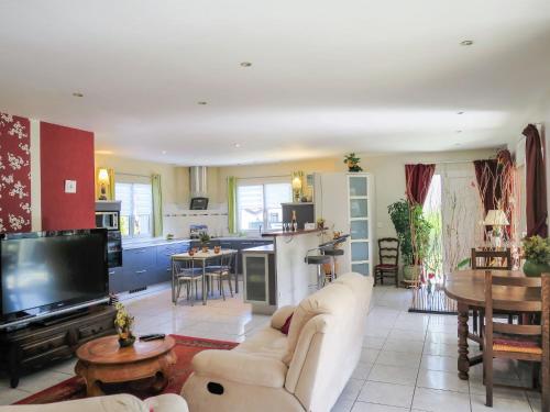 a living room with a couch and a tv and a kitchen at Holiday Home La Forêt - RES100 by Interhome in Arès