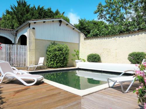 - une piscine avec 2 chaises et un canapé blanc dans l'établissement Holiday Home La Vertheuillaise by Interhome, à Vertheuil-en-Médoc