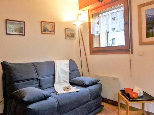 a living room with a blue couch and a lamp at Apartment L'Espace Montagne-5 by Interhome in Chamonix