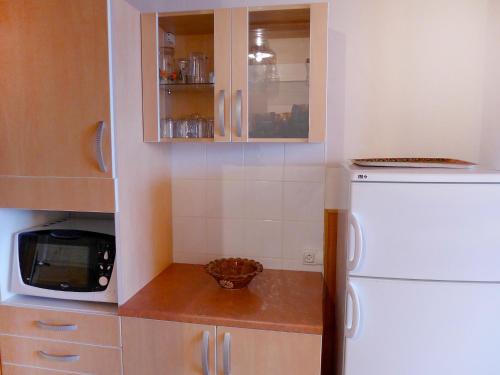 La cuisine est équipée d'un réfrigérateur blanc et d'un four micro-ondes. dans l'établissement Apartment Le 2100 A et B - Lavachet-7 by Interhome, à Tignes
