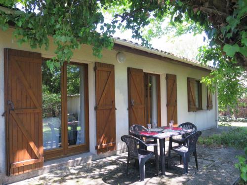 a table and chairs in front of a house at Holiday Home La Rose des Sables - RES120 by Interhome in Arès