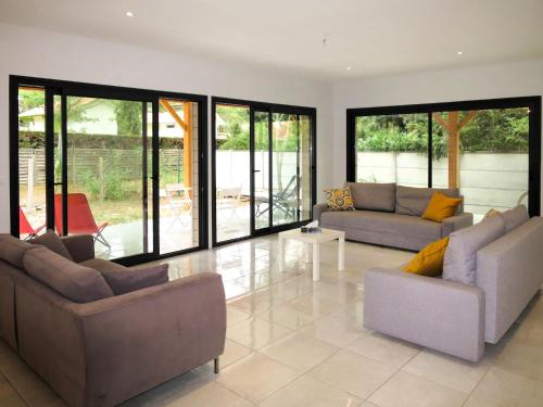 a living room with two couches and a table at Holiday Home Yara - LCA126 by Interhome in Lacanau