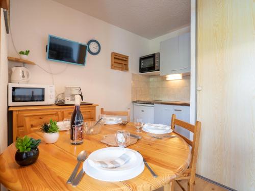 a kitchen with a wooden table with plates on it at Apartment Les Mousquetons-20 by Interhome in La Toussuire