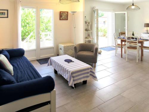 a living room with a couch and a table at Holiday Home Mon Poussin - SVV120 by Interhome in Saint-Vivien-de-Médoc