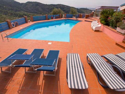 a swimming pool with blue and white chaise lounge chairs at Villa La Chiazza by Interhome in Corsanico-Bargecchia