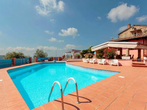 a swimming pool with chairs and a house at Villa La Chiazza by Interhome in Corsanico-Bargecchia