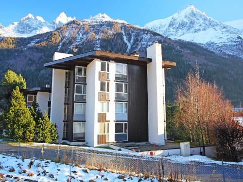 un bâtiment avec des montagnes enneigées en arrière-plan dans l'établissement Studio Arve 1 et 2-3 by Interhome, à Chamonix-Mont-Blanc