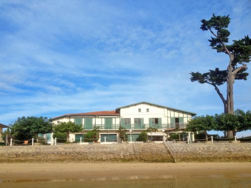 a white house with a tree in front of it at Studio Las Delicias by Interhome in Cap-Ferret