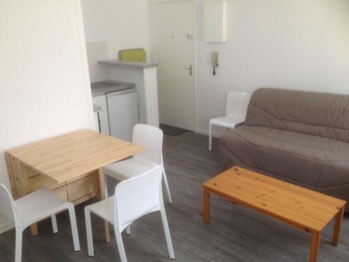 een woonkamer met een bank en een tafel en stoelen bij Studio Las Delicias by Interhome in Cap-Ferret