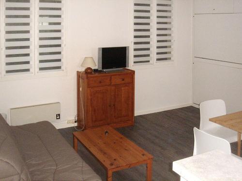 - un salon avec un canapé et une télévision sur une armoire dans l'établissement Studio Las Delicias by Interhome, à Cap-Ferret