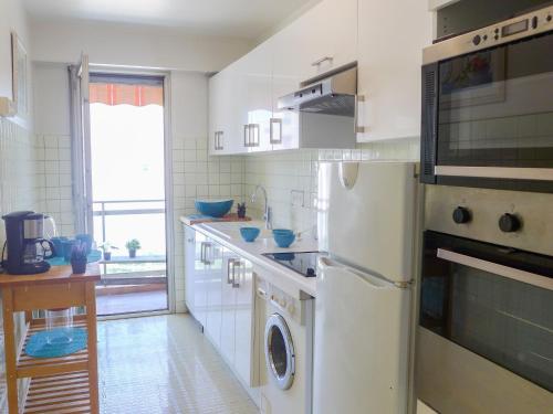 une cuisine blanche avec un lave-linge et un sèche-linge. dans l'établissement Apartment La Pinède-1 by Interhome, à Cagnes-sur-Mer