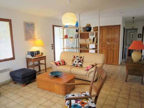 ein Wohnzimmer mit einer Couch und einem Sessel in der Unterkunft Holiday Home Caberal by Interhome in Soulac-sur-Mer