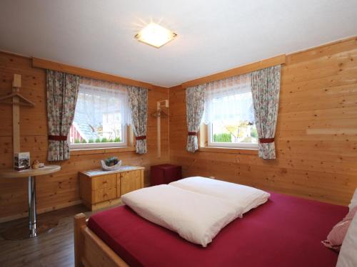a bedroom with a bed and two windows at Holiday Home Ötztal by Interhome in Oetz