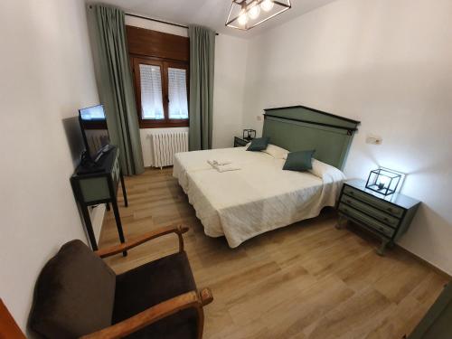 a bedroom with a bed and a chair in it at Casa La Plazuelilla in Chinchón