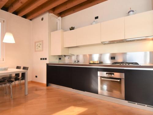 una cucina con mobili bianchi e neri e un tavolo di Apartment Iris by Interhome a Venezia
