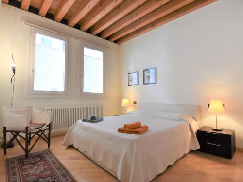 una camera con un letto e una sedia e due finestre di Apartment Iris by Interhome a Venezia