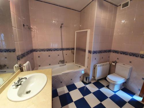a bathroom with a sink and a toilet and a tub at Casa La Plazuelilla in Chinchón