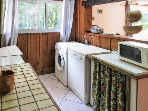 een keuken met een wasmachine en een magnetron bij Holiday Home Castagney by Interhome in Gaillan-en-Médoc