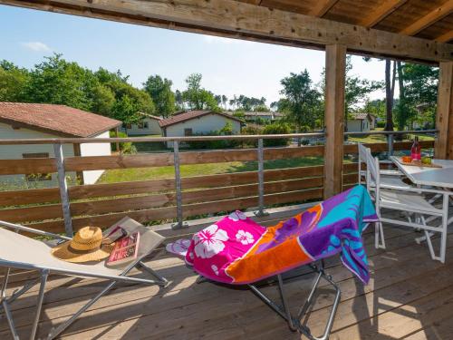 una terrazza con sedie e tavoli con vista di Apartment Les Cottages du Lac T2 by Interhome a Parentis-en-Born