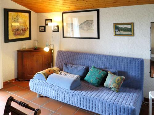 a blue couch sitting in a living room with pillows at Apartment Petite Ramaline - LCA166 by Interhome in Lacanau-Océan