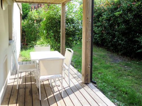 eine Veranda mit einem Tisch und Stühlen darauf in der Unterkunft Apartment Les Cottages du Lac T1 by Interhome in Parentis-en-Born
