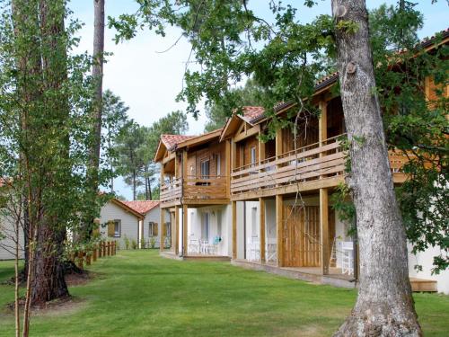 ein Haus im Wald mit Garten in der Unterkunft Apartment Les Cottages du Lac T1 by Interhome in Parentis-en-Born