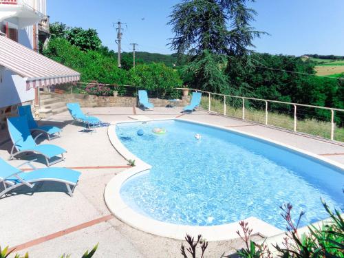 a swimming pool with blue chairs at Holiday Home Lacapelle - LPR100 by Interhome in Lacapelle-Ségalar