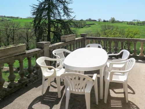 a white table and four chairs on a balcony at Holiday Home Lacapelle - LPR100 by Interhome in Lacapelle-Ségalar