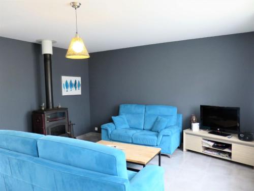 a living room with blue chairs and a tv at Holiday Home Dorgeles - SUL130 by Interhome in Soulac-sur-Mer