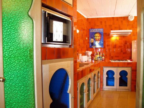 Il comprend une cuisine dotée de murs en carrelage orange et une télévision. dans l'établissement Holiday Home Schöner Stern by Interhome, à Bendéjun