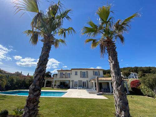 dos palmeras delante de una casa en Villa Les Cycas - GRI170 by Interhome en Grimaud
