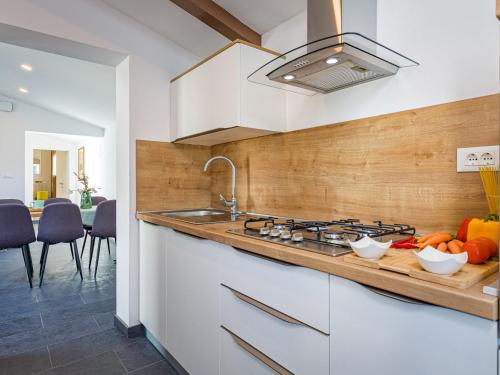 een keuken met een wastafel en een fornuis top oven bij Holiday Home Prenc - PZN212 by Interhome in Munci