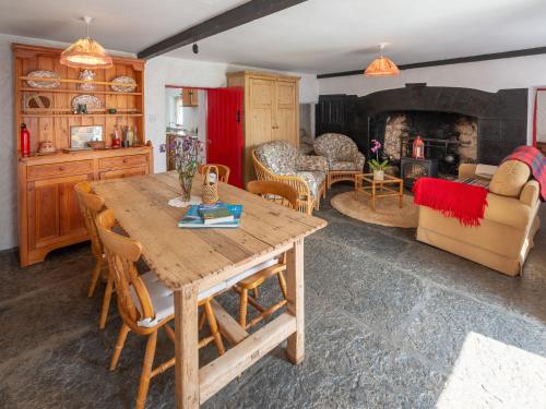 een woonkamer met een houten tafel en een open haard bij Holiday Home The Neale by Interhome in Cross